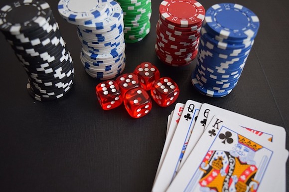 Casino Spiele - Würfel, Chips und Karten auf dem Tisch liegend